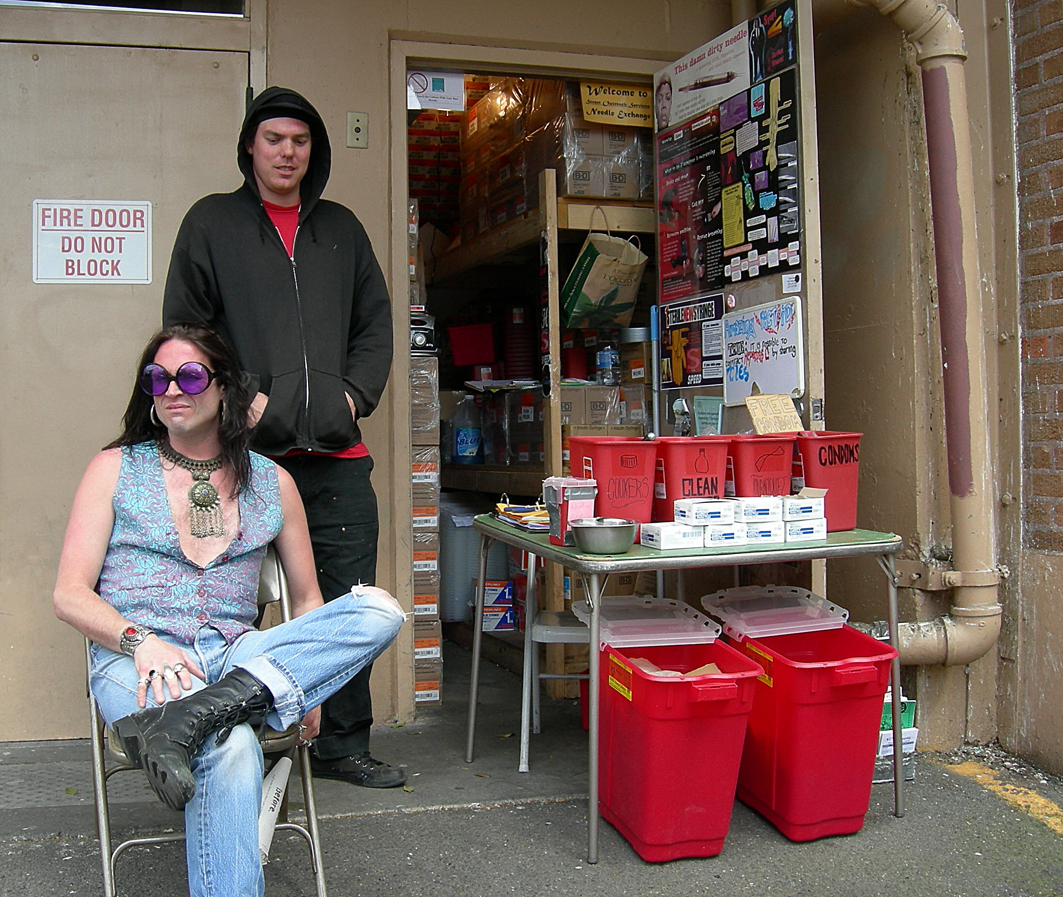 Harm reduction workers staffing an urban syringe access site with sterile supplies and safe disposal containers